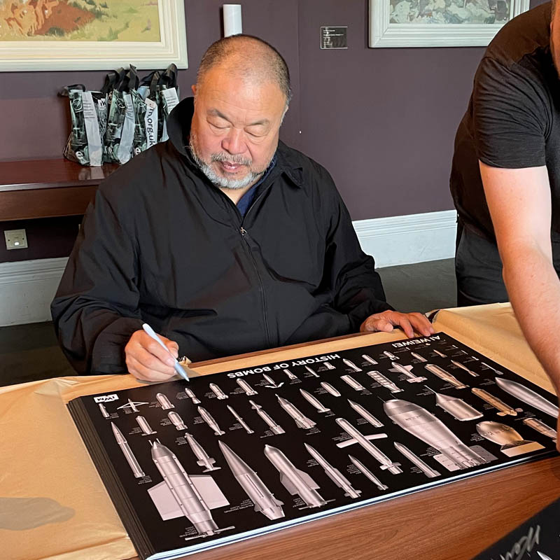 ai weiwei artist hand signing posters at imperial war museums history of bombs